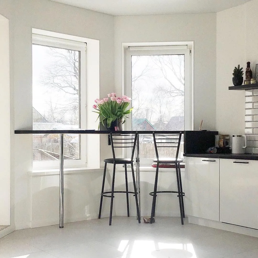 Чёрная барная стойка на белой кухне у окна