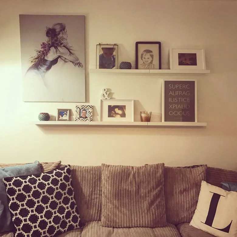 Полка с картинами над диваном