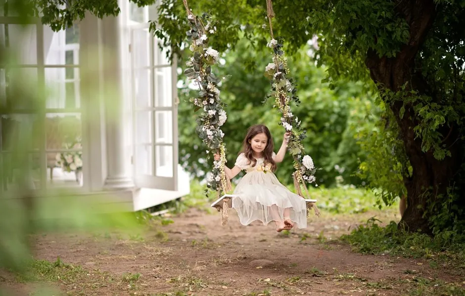 Девочка на качелях в саду