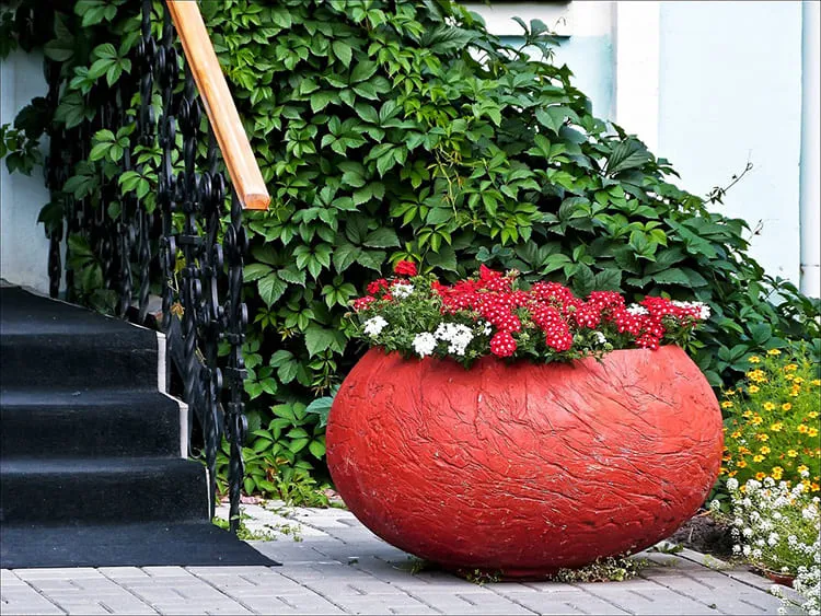 Яркий вазон будет отлично смотреться в тенистом уголке сада, если в него посадить теневыносливую хосту, плющ или цветы